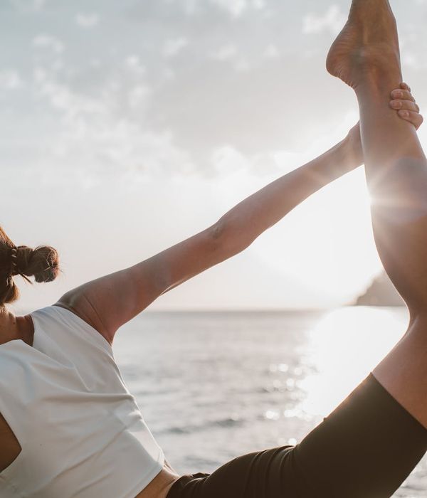 Woman performing a gentle stretching yoga pose outdoors in nature.